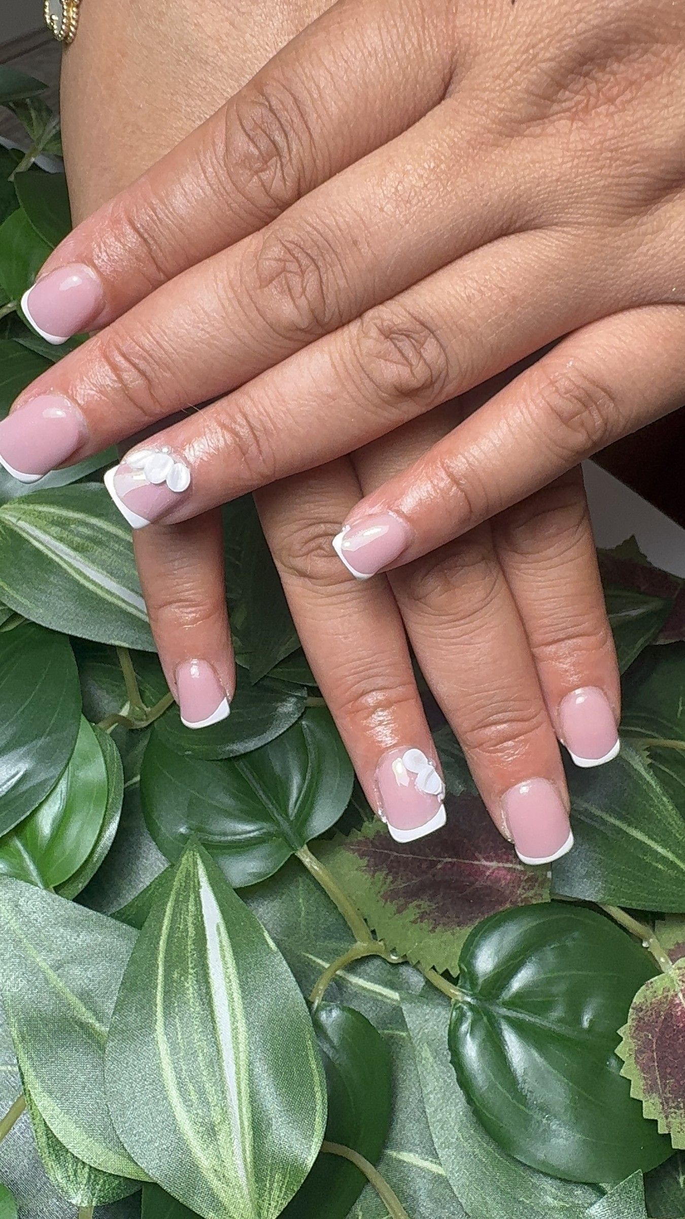 Short BIAB French tips with a white flower accent